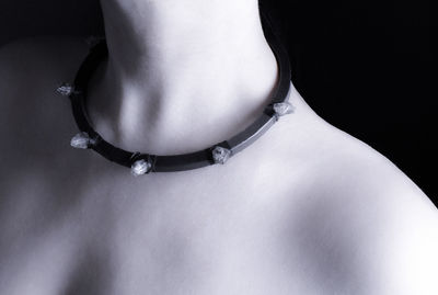 Close-up of shirtless woman against black background