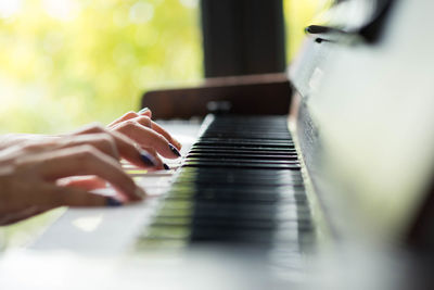 Cropped hands playing piano