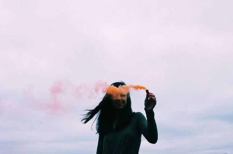 LOW ANGLE VIEW OF YOUNG WOMAN WITH BIRDS ON BACKGROUND