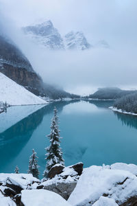 Scenic view of frozen lake by snowcapped mountain