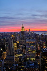 Illuminated buildings in city during sunset