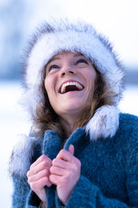 Portrait of smiling young woman wearing warm clothes during winter