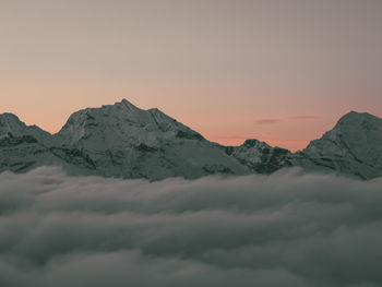 Scenic view of snowcapped mountains against sky during sunset