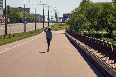 Rear view of man walking on road