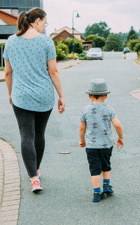 Rear view of woman walking on road