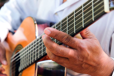 Midsection of man playing guitar