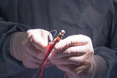 Midsection of surgeon holding medical equipment