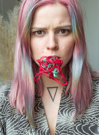 Close-up portrait of woman with threads on mouth