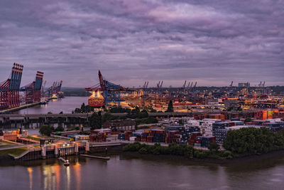 Illuminated cityscape against sky during sunset