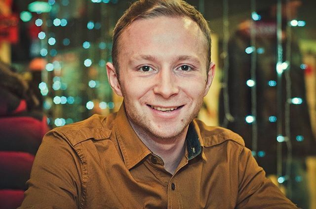 portrait, looking at camera, lifestyles, person, headshot, front view, casual clothing, focus on foreground, leisure activity, young men, young adult, smiling, head and shoulders, close-up, indoors, happiness, stubble