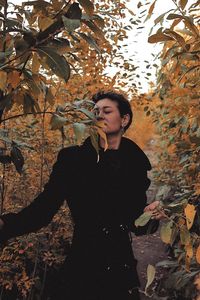 Full length of young man standing on autumn leaves