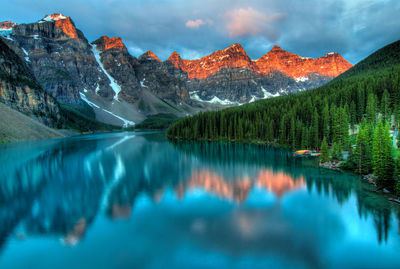 Scenic view of lake by snowcapped mountains against sky