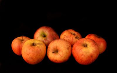Seven ripe apples on a black background