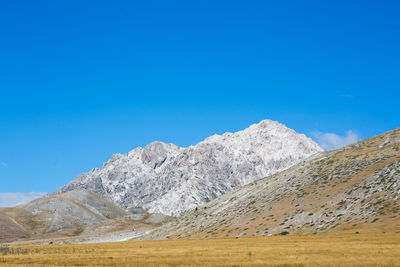 Scenic view of mountains against clear blue sky