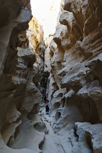 People on rock formation in cave