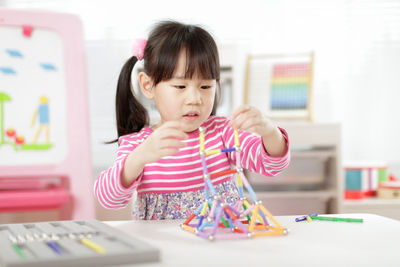 Cute girl playing with toy at home