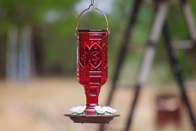 Close-up of red bell hanging on metal structure