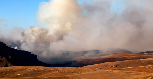 Smoke emitting from volcanic mountain against sky