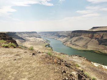 Scenic view of river against cloudy sky