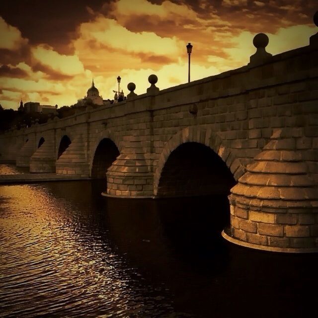 architecture, built structure, sunset, arch, sky, water, building exterior, connection, waterfront, bridge - man made structure, river, reflection, arch bridge, silhouette, cloud - sky, bridge, outdoors, orange color, dusk, no people