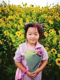 Cute girl standing at sunflower farm