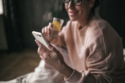 Midsection of woman using mobile phone