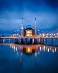 Reflection of illuminated building in water at night