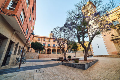 Street amidst buildings in town against clear sky