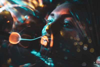 Close-up of young woman kissing lighting equipment