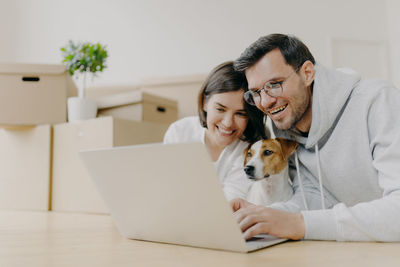 Smiling couple using laptop at home