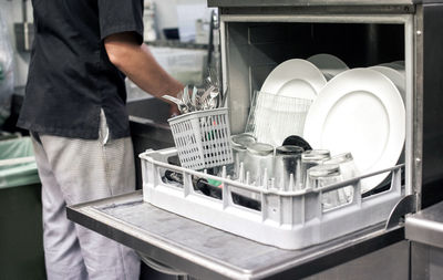 Midsection of man working in kitchen