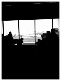 Silhouette of man looking through window