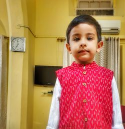 Portrait of boy wearing traditional clothes standing at home