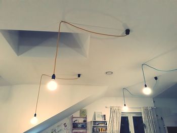 Low angle view of illuminated pendant light hanging from ceiling