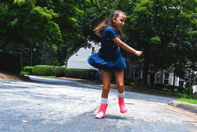 Full length of girl dancing on road