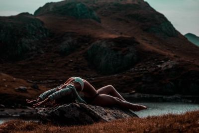 Woman lying on rock