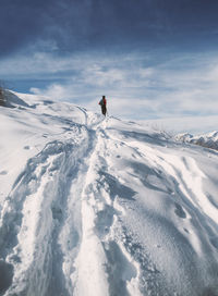 People walking on snow covered landscape