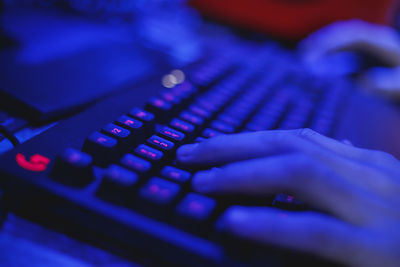 Cropped image of man using computer keyboard while playing game