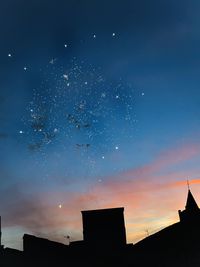 Low angle view of silhouette buildings against sky at night