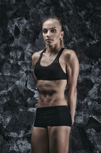 Portrait of woman standing against wall