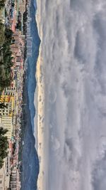 View of cityscape against cloudy sky