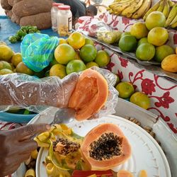 Une vendeuse de fruit epulce une papaye 