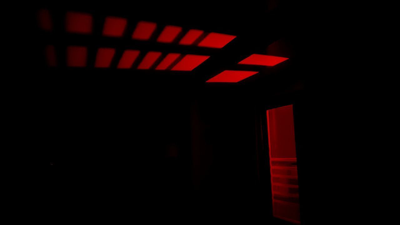 LOW ANGLE VIEW OF ILLUMINATED LIGHTS IN DARKROOM