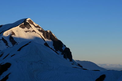 Scenic view of snowcapped mountains against clear blue sky