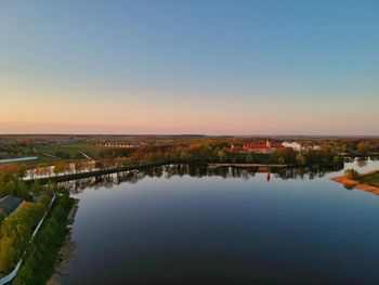 Scenic view of lake against clear sky during sunset