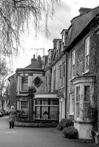 Man on street by old building against sky