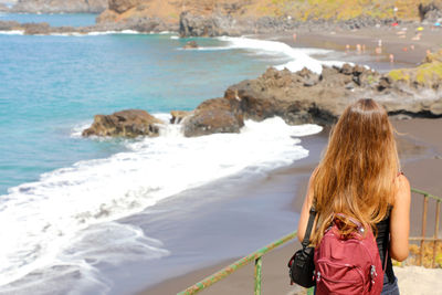 Rear view of woman looking at beach