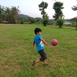 Boy playing with ball on field