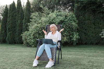 Young beautiful business woman working on a laptop, freelancer works in nature. 