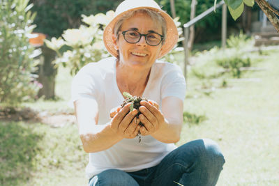 Portrait of mature woman holding soil